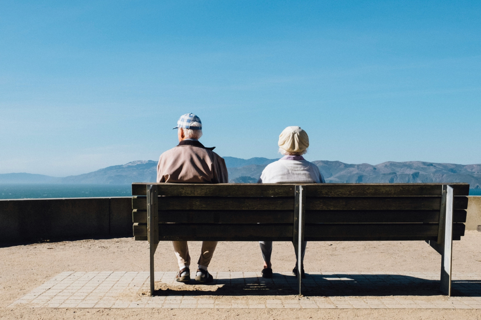Older couple sitting outside looking at the lake and mountain view